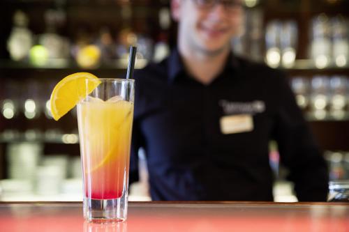 a drink sitting on a table with an orange slice at Hotel der Lennhof in Dortmund