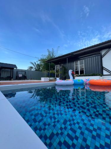 a swimming pool with a swan in the middle of it at Rimbun Bayu Homestay in Kuala Terengganu