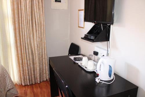 a room with a desk with a coffee maker on it at Boikhutsong Bed & Breakfast in Maseru