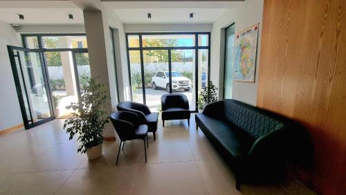uma sala de estar com um sofá e cadeiras e um carro em SIBB Hotel em Tirana