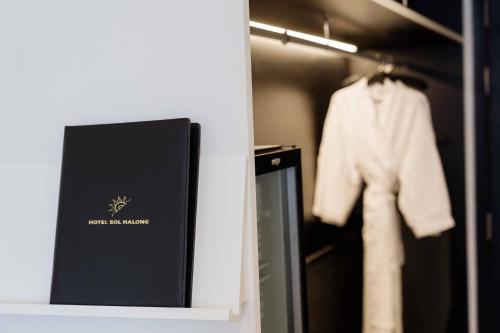 a book sitting on a shelf next to a closet at Hotel Soleil Ha Long, Trademark Collection by Wyndham in Ha Long