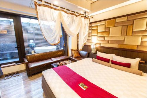 um quarto com uma cama, um sofá e uma janela em HOTEL PetitBali Higashi-Shinjuku em Tóquio