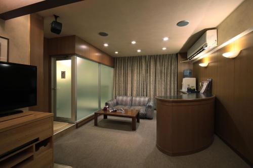 a hotel room with a waiting area with a television at Hotel Mio Plaza (Adult Only) in Yokkaichi