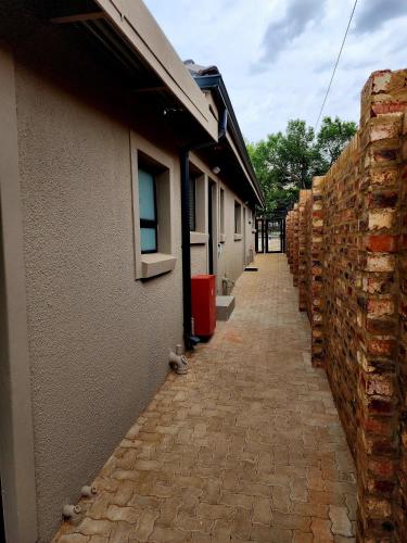 a brick sidewalk next to a building and a brick wall at 80 on Thabo in Potchefstroom