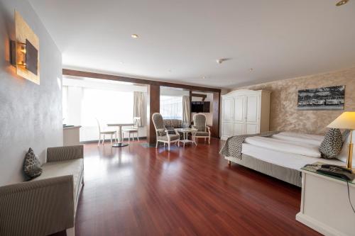 a bedroom with a bed and a living room at Seilers Vintage Hotel & Spa in Kandersteg