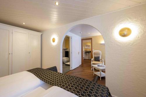 a bedroom with a bed and a living room at Seilers Vintage Hotel & Spa in Kandersteg
