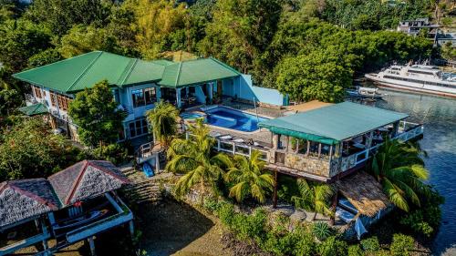an aerial view of a large blue house on the water at Edgewater Dive & Spa Resort in Puerto Galera