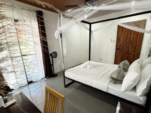 a bedroom with a canopy bed in a room at Mahajab Homestay SIARGAO in General Luna
