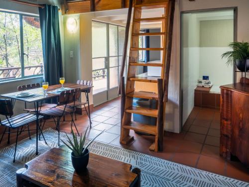 Olifants River Lodge by Dream Resorts في ميدلبرغ: غرفة طعام مع طاولة وكراسي وسلم