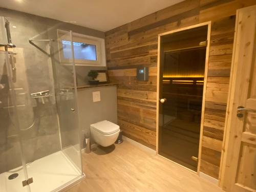 een badkamer met een toilet en een glazen douche bij Lina's Ferienwohnungen - zwei moderne FeWos mit Sauna im Haus und fantastischem Ausblick in Sankt Andreasberg