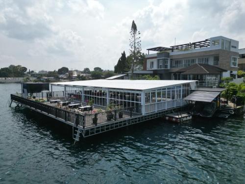 a house on a dock in the water at PURNAMA BALIGE HOTEL in Balige