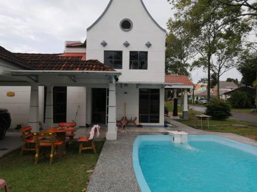 une maison avec une piscine en face d'une maison dans l'établissement Hilal Sofia 933villa dfaro, Afamosa Resort Malacca, à Kampong Alor Gajah