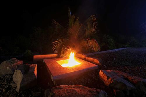a fire pit in the ground at night at Open House by StayVista - Nestled in nature, featuring a Swimming pool & Expansive lawn for a serene retreat in Shikrapur
