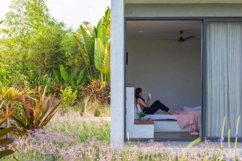 two women laying on a bed in a house at Open House by StayVista - Nestled in nature, featuring a Swimming pool & Expansive lawn for a serene retreat in Shikrapur