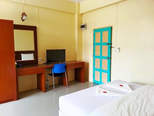 a bedroom with a desk with a computer and a blue door at Wansiri Mansion in Songkhla