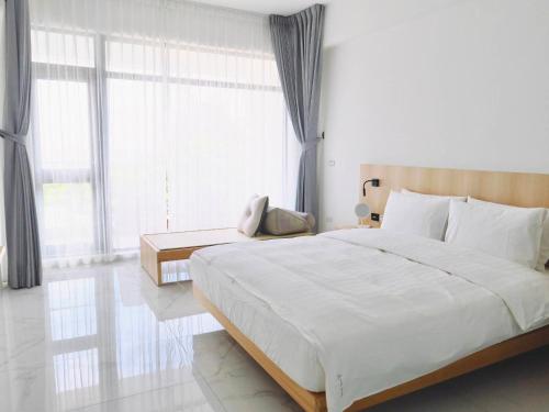 a bedroom with a large bed and a large window at Kenting Onehome in Checheng