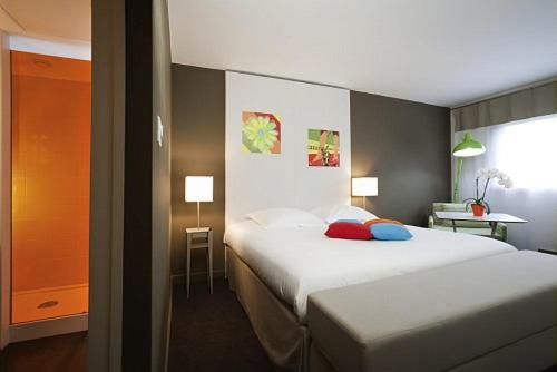 Ibis Styles Annemasse Genève في أمْبييّي: غرفة فندقية بسريرين ونافذة