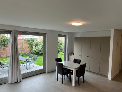 een keuken en eetkamer met een tafel en stoelen bij Appartement Huis op het Duin in Egmond aan Zee