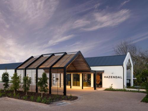 a large white building with a black roof at The Hazendal Hotel and Homestead in Stellenbosch