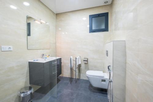a bathroom with a toilet and a sink and a tv at Asilah 32 in Asilah
