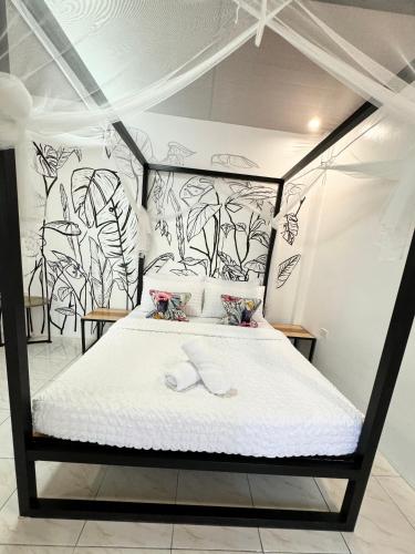a bedroom with a bed with a black and white wall at Mahajab Homestay SIARGAO in General Luna