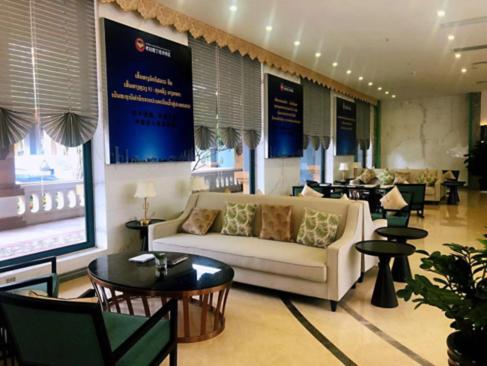 a lobby with a couch and tables and chairs at 慧兰酒店bodhi hotel in Ban Botèn