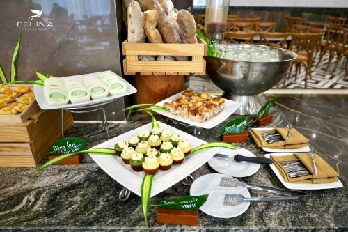Ein Tisch, gedeckt mit Vorspeisen und Gebäck auf Tellern. in der Unterkunft Celina Peninsula Resort Quảng Bình in Dong Hoi