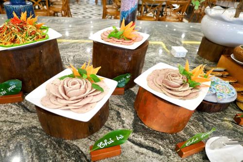 einen Tisch mit drei Teller Essen darüber in der Unterkunft Celina Peninsula Resort Quảng Bình in Dong Hoi