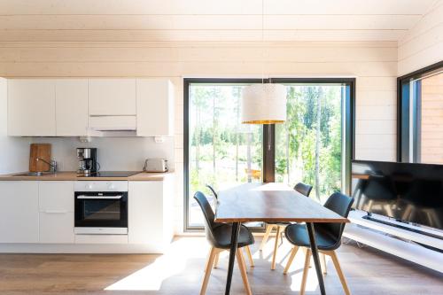 a kitchen and dining room with a table and chairs at Himoskuutio 8, erillistalo, ulkoporeallas in Jämsä