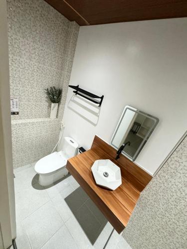 a bathroom with a toilet and a sink and a mirror at Mahajab Homestay SIARGAO in General Luna