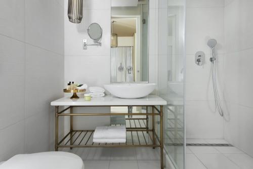 Baño blanco con lavabo y espejo en Hotel Rothschild 22 en Tel Aviv