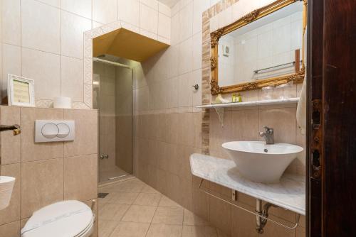 a bathroom with a sink and a toilet and a mirror at Heritage Hotel Pasike in Trogir