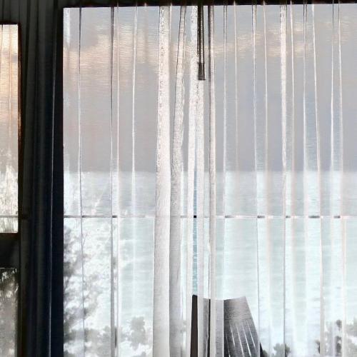 a window with curtains and a chair in a room at Kenting Onehome in Checheng