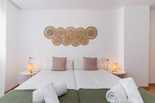 ein Schlafzimmer mit einem großen weißen Bett mit zwei Lampen in der Unterkunft MONKÓ PICASSO in Torremolinos