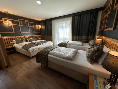 a hotel room with two beds and a window at Hotel Belen Fahrenkrug in Fahrenkrug