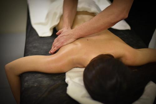 un hombre recibiendo un masaje de espalda en una cama en MYR Marqués House, en Valencia