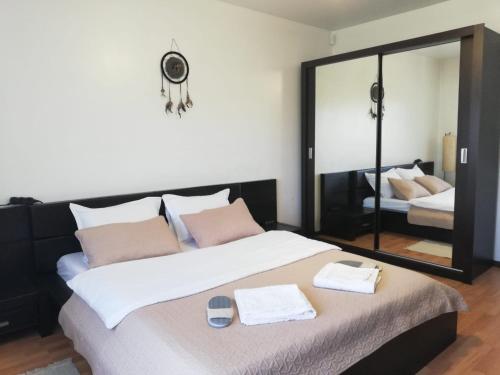 1 dormitorio con 1 cama grande y espejo en Cozy villa, close to the center of Bucharest., en Bragadiru