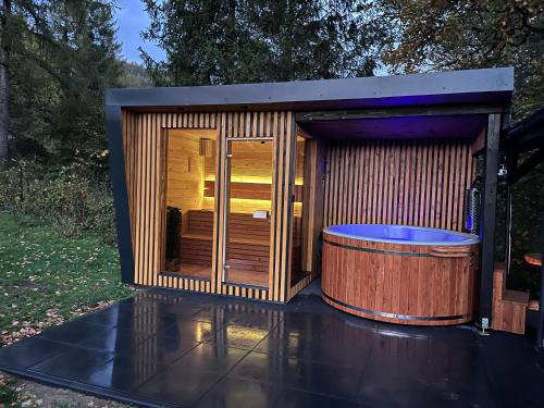 a sauna with a hot tub on a patio at Szopówka Pod Grodziskiem in Dukla