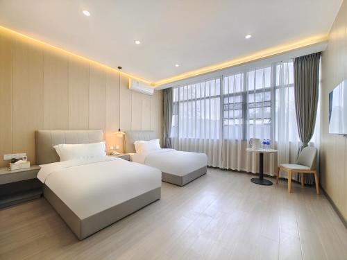 a hotel room with two beds and a table at Airport Dream B&B - Tianfu International Airport Branch in Jianyang