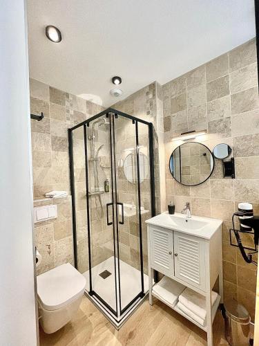 a bathroom with a shower and a toilet and a sink at Hôtel Le Bel Air in Saint-André-les-Alpes