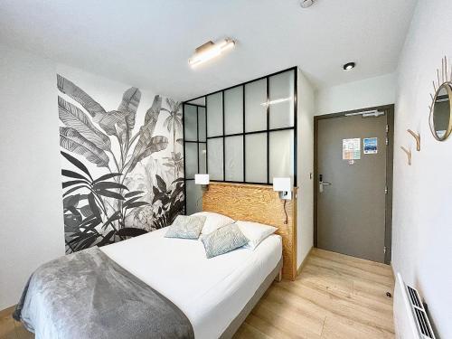 a bedroom with a bed and a large mural on the wall at Hôtel Le Bel Air in Saint-André-les-Alpes