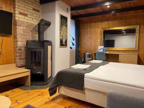 a bedroom with a bed and a wood stove at Duarto house, Sauna and Hot Tub in Šiaudinė