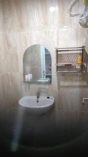 y baño con lavabo y espejo. en Apartemen Skylounge Makassar en Manda