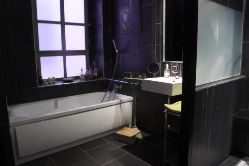 La salle de bains est pourvue d'une baignoire et d'un lavabo. dans l'établissement Bartissol et Maillol, à Perpignan