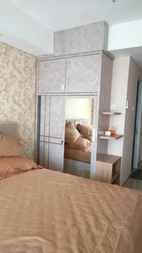 Un pat sau paturi într-o cameră la Apartemen Skylounge Makassar