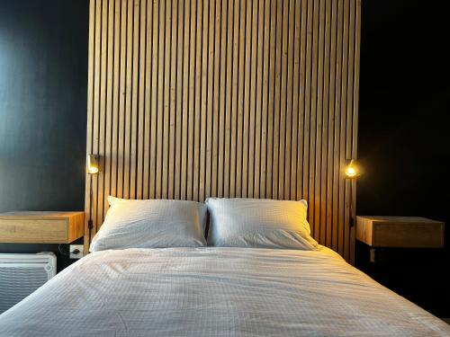 a bedroom with a large bed with two lights on it at Appartement de standing avec parking privé in Cherbourg en Cotentin