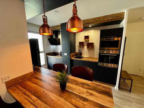 a kitchen and dining room with a wooden table at Appartement de standing avec parking privé in Cherbourg en Cotentin