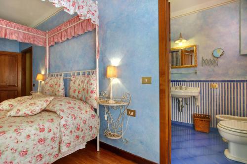 a bedroom with a canopy bed and a bathroom at Villa Perla - Homelike Villas in Reggello