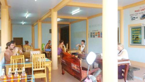 a group of people sitting at tables in a restaurant at Peace Lanta Mansion in Ko Lanta