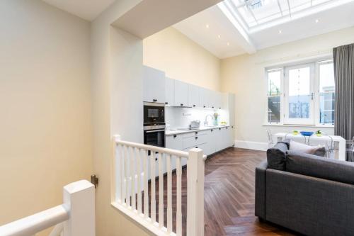 a living room with a staircase and a kitchen at 2-BR apartment for 6 in Covent Garden with ac in London